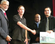 Bjorn Pentikainen (centre) shakes hands with Victor Marques at the ceremony